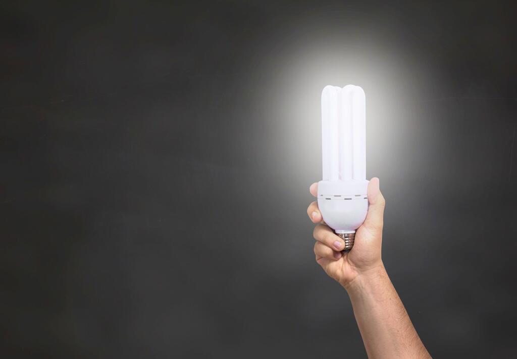 Roka drži prižgano LED žarnico