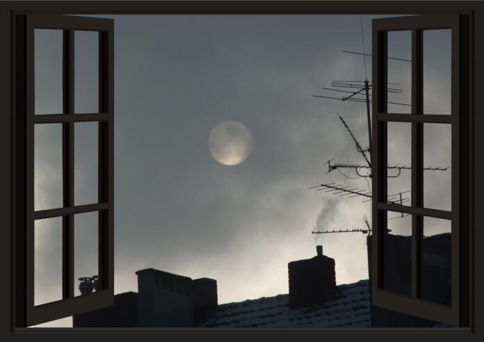 Odprta okna, vidi se luno in strehe hiš
