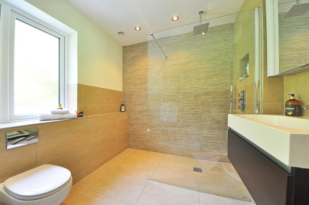 Steklena stena v kopalniški tuš kabini lahko vizualno in fizično poveča prostor