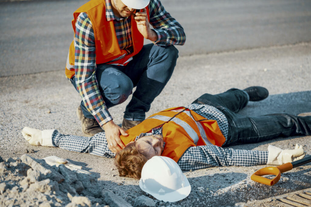 Worried man calling ambulance for his uncosncious coworker