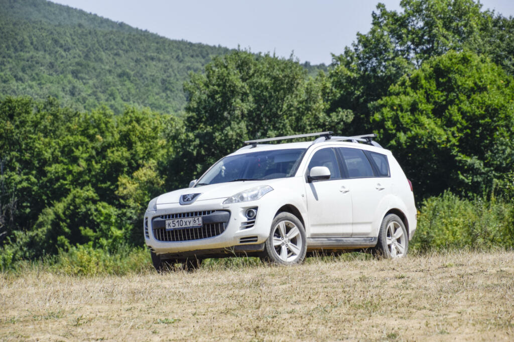 Forests next to the village of Shapsugskaya, Russia - July 30, 2016: White crossover Peugeot 4007 on the hill.