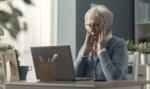 Senior woman struggling with technology, she is confused and staring at the computer screen