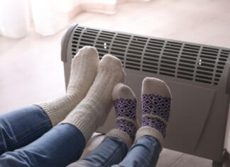 Optimalno dogrevanje sob: najbolj učinkoviti načini ogrevanja sob (v 2022) Mother and child warming feet near electric heater at home, closeup
