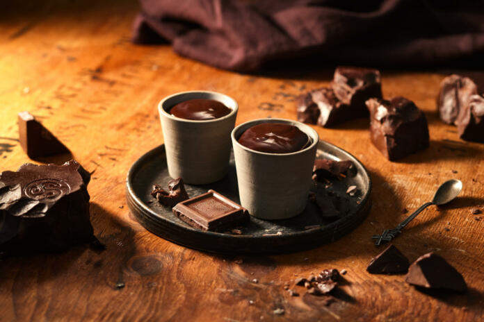 Dve skodelici vroče čokolade na pladnju na leseni mizi