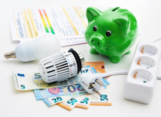 Spletni kalkulator: izračunajte višino energetskega dodatka Energy cost, saving energy concept. Piggy bank with money, plug, bulb and radiator thermostat on white background