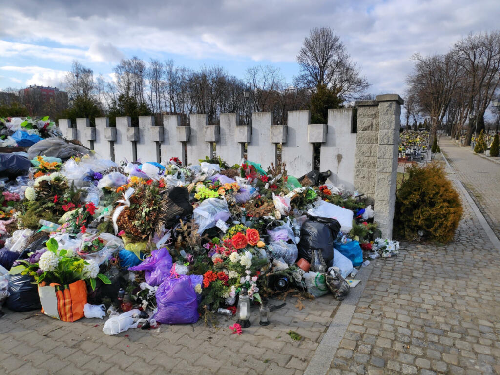 Garbage at a cemetery in Poland. Dicarded used grave candles, plastic flowers and decorations.