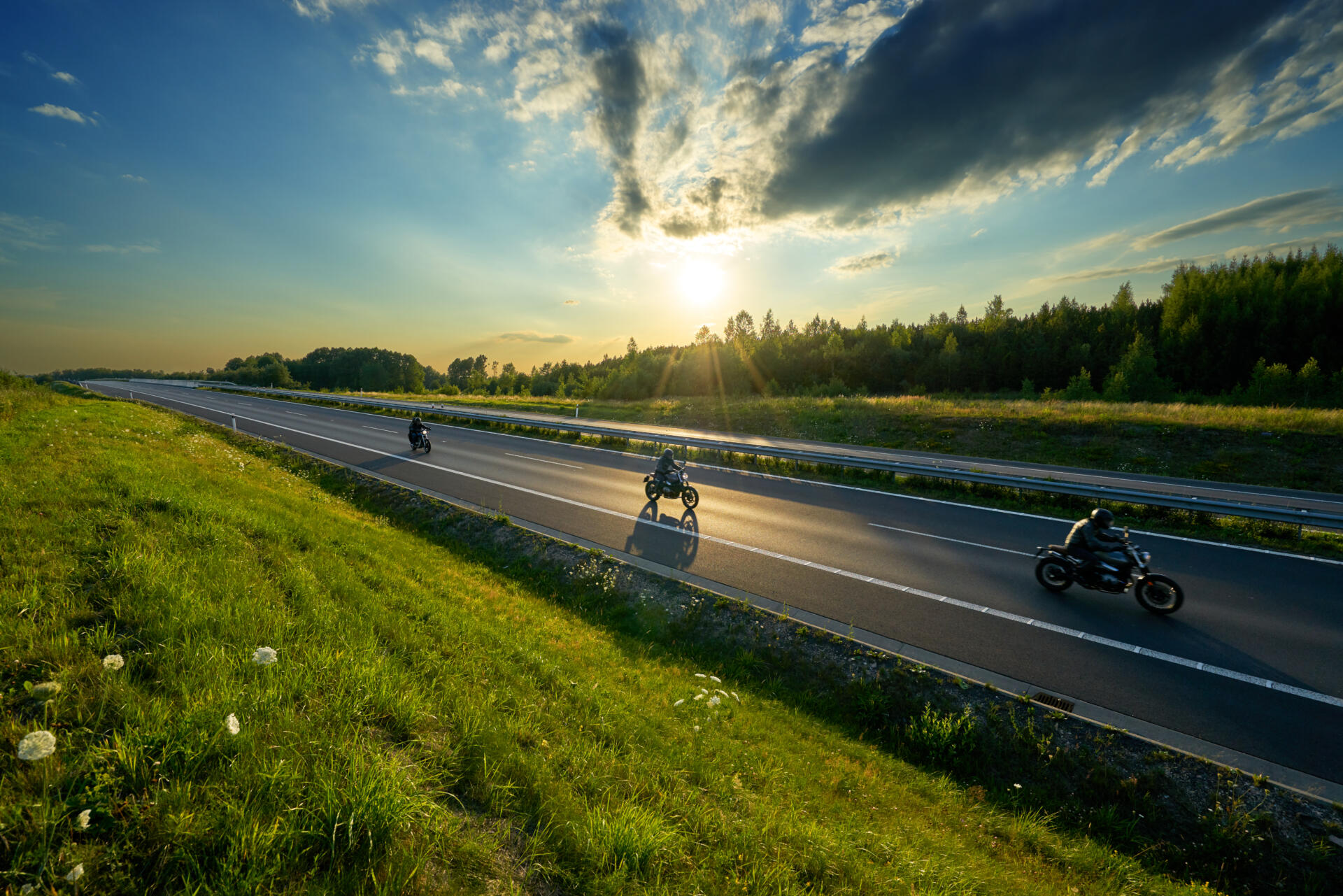 Motorcycles riding on the highway in the countryside in the rays of the sunset