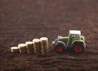 Slovenija bo namenila skoraj dve milijardi za kmetijsko politiko Tractor miniature with coins on fertile soil land