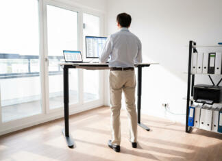 Nastavljiva miza: Prednosti nastavljivih miz za vaše telo Man Working On Computer At Standing Desk In Home Office