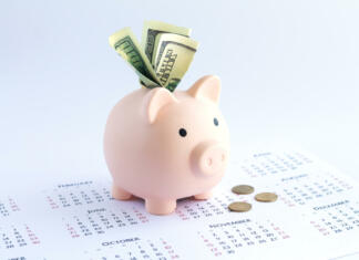 Piggy bank with dollars and coins on calendar. Deposit or savings money concept