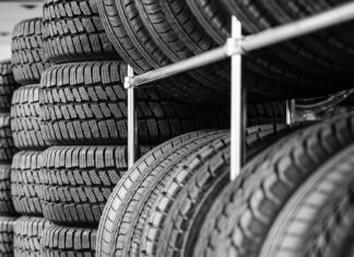 Kako shranjevati pnevmatike? Rack with variety of new car tires in automobile store, selective focus