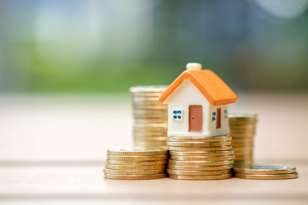 Mini house on stack of coins. Concept of Investment property.