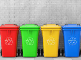 Multicoloured Garbage Trash Bins in front of brick wall. 3d Rendering