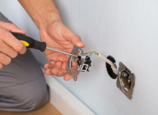 Kako montirati ali zamenjati vtičnico? (VIDEO) Close-up Of Electrician Hands With Screwdriver Installing Wall Socket