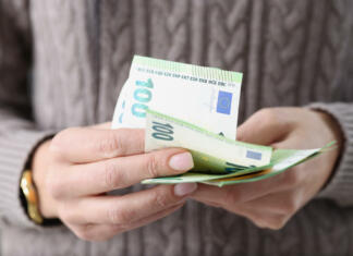 Zvišali se bodo otroški dodatki, štipendije in socialna pomoč! Dvig bo vplival na določene stvari … One hundred euro banknotes in female hands. Savings in European countries concept