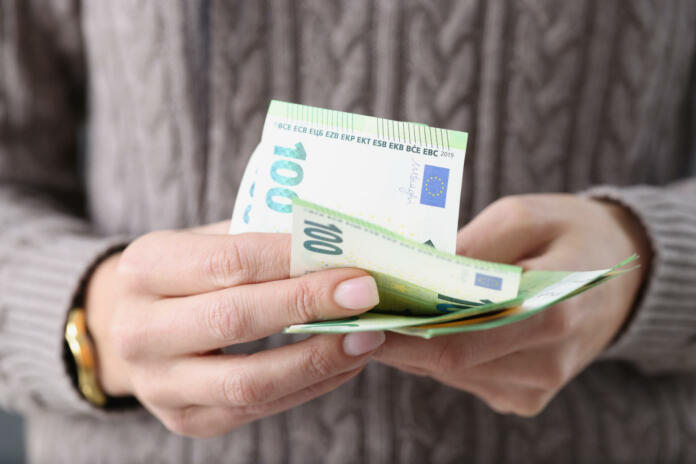 One hundred euro banknotes in female hands. Savings in European countries concept
