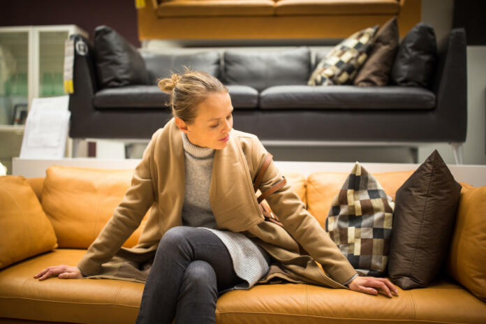 nakup kupec stranka kavč sedežna garnitura Pretty, young woman choosing the right furniture for her apartment