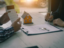 kredit nakup nepremičnine kreditna sposobnost Real estate professionals offer their clients contracts to discuss home purchases, insurance or real estate loans. Home sales agents sit at the office with new home buyers in the office.
