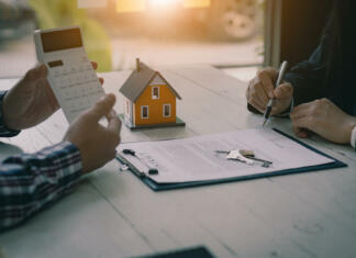 kredit nakup nepremičnine kreditna sposobnost Real estate professionals offer their clients contracts to discuss home purchases, insurance or real estate loans. Home sales agents sit at the office with new home buyers in the office.