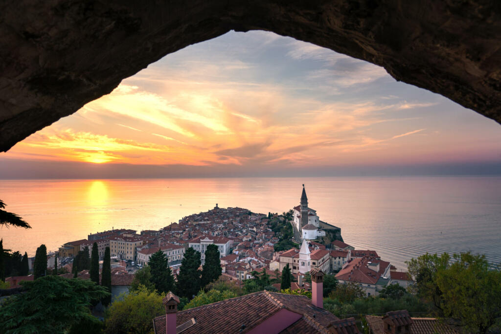 stunning sunset view from the piran city walls Piransko obzidje through wall window arch .