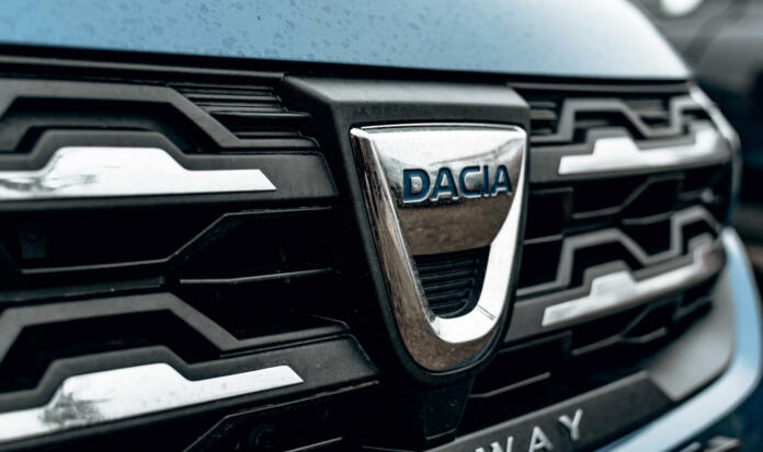 Zagreb, Croatia – December 30, 2021: A black and chrome trim around Dacia logo on front of silver car