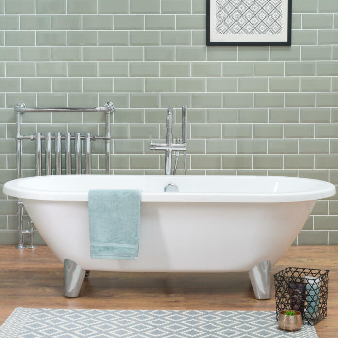 A bathtub in a bathroom with laminate flooring and ceramic tiled wall, a loft style apartment