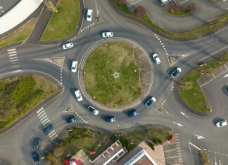 Ta občina bo dobila novo krožišče Aerial view of road roundabout intersection with fast moving heavy traffic. Urban circular transportation crossroads.
