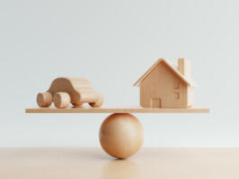 House and car coin with balancing weight scale on wooden background. Financial and Transportation production concept. Loan and real estate theme. 3D illustration rendering