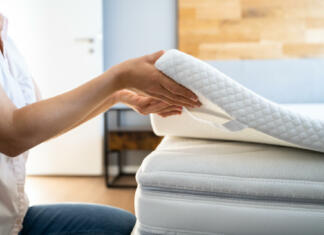 Mattress Topper Being Laid On Top Of The Bed