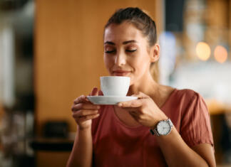To so najpogostejše napake, ki jih delamo pri kuhanju kave in pokvarijo njen okus Dekle z nasmeškom pije kavo.
