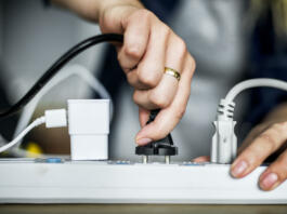 Woman plugging the wire to the outlet