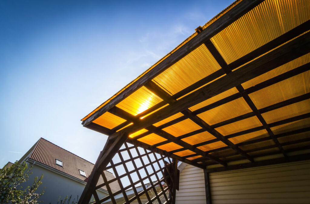 The roof of the veranda of orange polycarbonate on blue sky background.