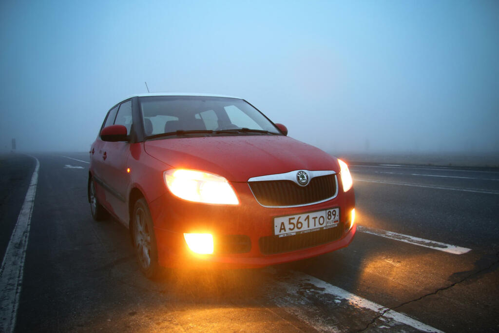 Yamal, Russia - May 25, 2016: Red compact car Skoda Fabia SE in a strong fog.