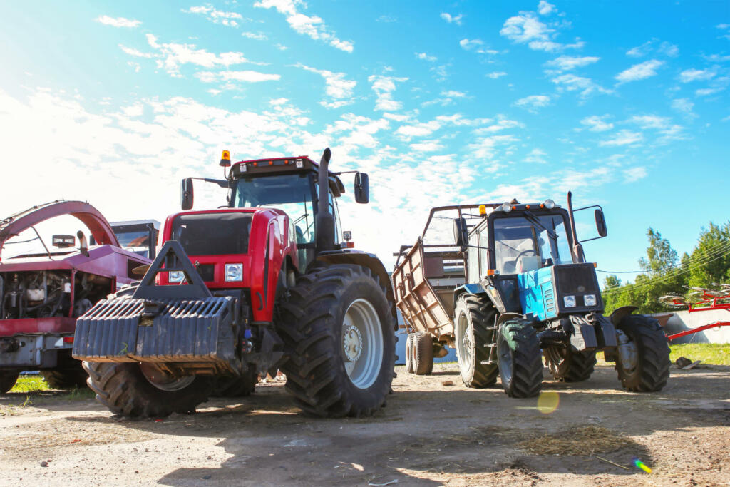 Agricultural machinery, tractors and equipment outdoors, near the garage, ready to work in the field.