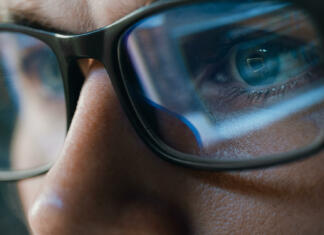 Očala za modro svetlobo: Prednosti in slabost Close-up Portrait of Software Engineer Working on Computer, Line of Code Reflecting in Glasses. Developer Working on Innovative e-Commerce Application using Machine Learning, AI Algorithm, Big Data