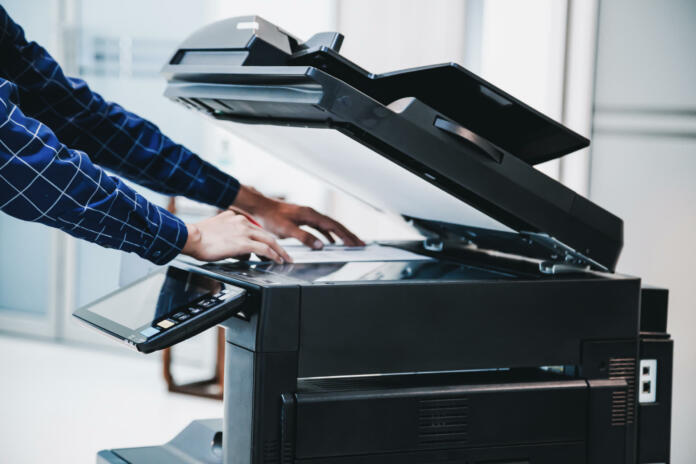 Copier printer, Close up hand office man press copy button on panel to using the copier or photocopier machine for scanning document printing a sheet paper.