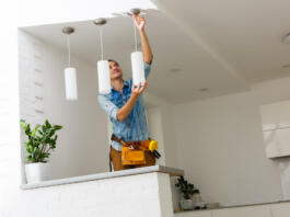 Electrician is installing and connecting a lamp to a ceiling.