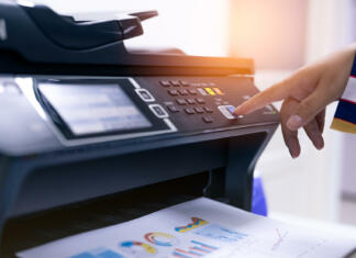 Najem tiskalnika brez plačevanja naprej Office worker print paper on multifunction laser printer. Copy, print, scan, and fax machine in office. Modern print technology. Photocopy machine. Document and paper work. Professional scanner.