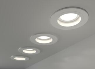 Vzporedna vezava luči: Kako vezati več luči? Spotlights recessed ceiling 3D render. Realistic interior room with round glowing downlights at night. Artificial lighting, LED lamps for home or office on dark background angle view, 3D illustration