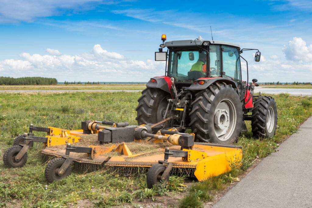 Wheel tractor with lawn mower by the road