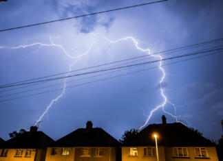 Kako zaščititi naprave pred udarom strele: 5 učinkovitih načinov Lightning Storm in the Night Sky Above Residential Houses in Essex, UK.