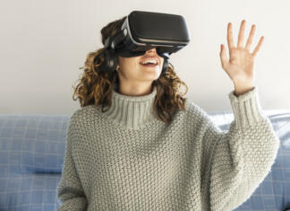 Meta in Apple v bitki za prevlado nad virtualno resničnostjo woman using vr glasses at home