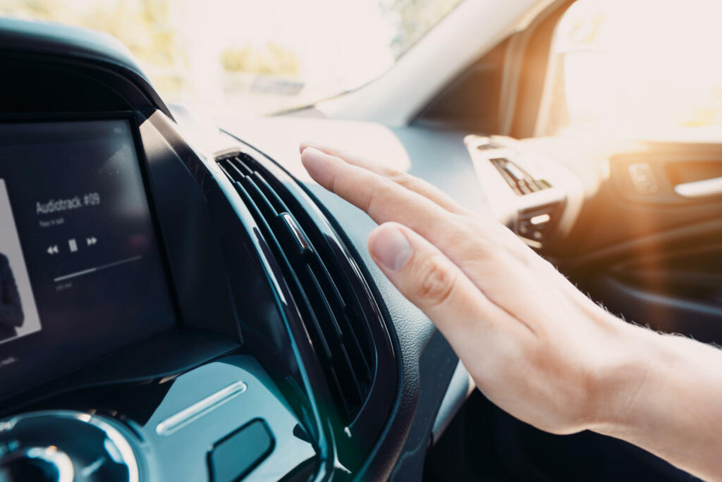 Hand checking the air conditioner in the car. The cooling system in the car