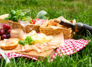 5 nasvetov za najboljši piknik tega leta Picnic blanket with wine and food on green grass