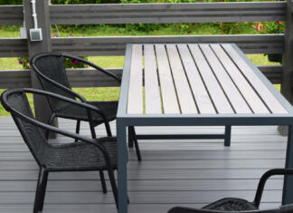 WPC plošče kot trajnostna alternativa lesu za vrtne tlakove in ograje: Prednosti in slabosti! Plastic chairs and wooden table on WPC flooring terrace outdoors. Home outdoor terrace with empty patio furniture.