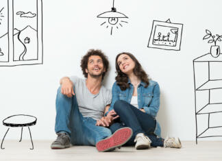 Na voljo ugodni krediti s spremenljivo ali fiksno obrestno mero, premislite si lahko tudi v dobi odplačevanja kredita Portrait Of Happy Young Couple Sitting On Floor Looking Up While Dreaming Their New Home And Furnishing