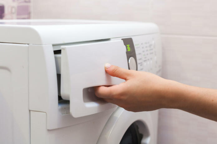 She pours the liquid powder in washing machine