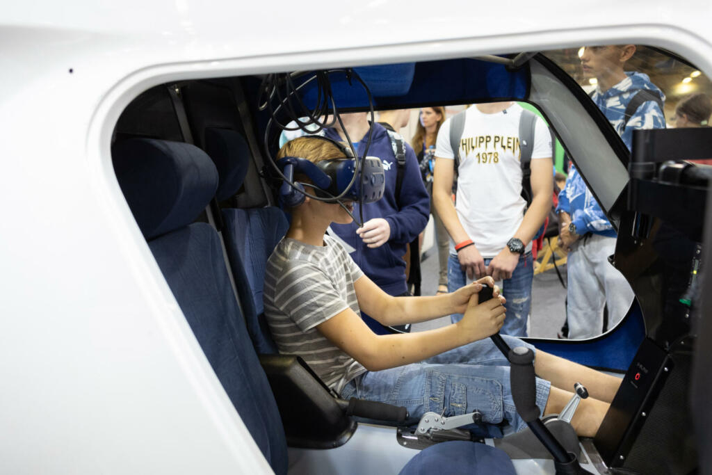 Fant sedi v avtomobilu, na glavi ima pametna očala za izkušnjo virtualne resničnosti