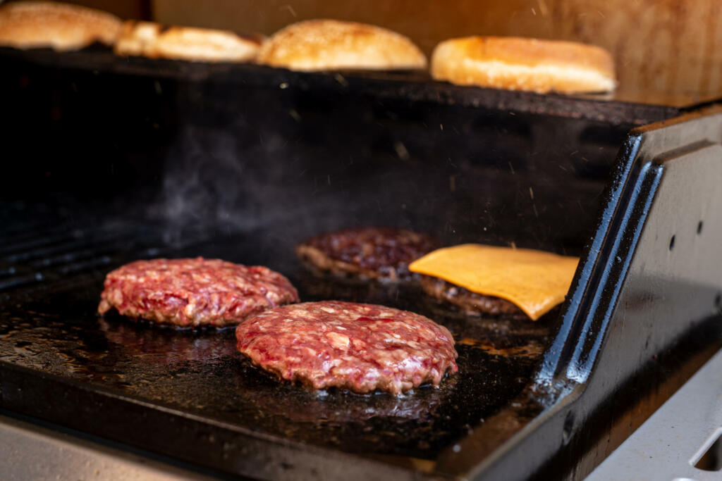 Hamburgers cooking on the grill. Beef or pork barbecue hamburger for hamburger. Hamburgers on bbq .