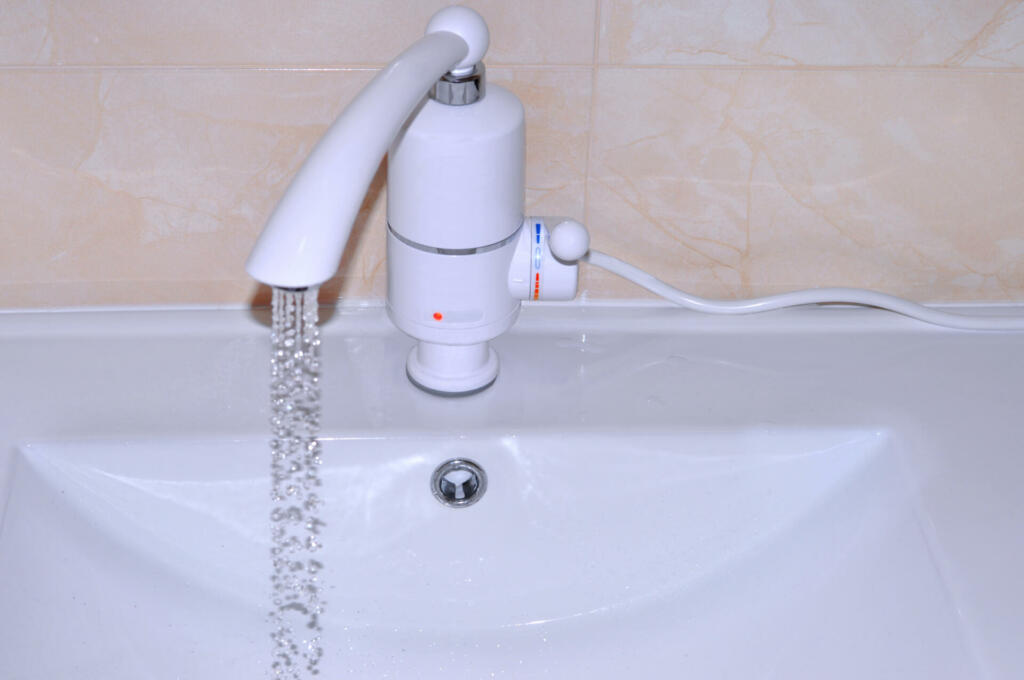 Modern chrome-plated tap fitted with plastic with built-in electric water heater. When the handle is raised, the hot water comes out. When the handle is lowered, cold water comes out